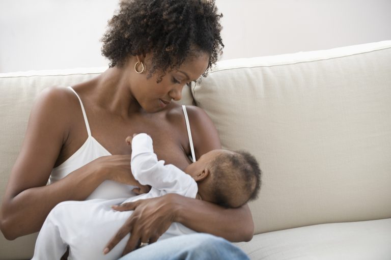 Mother nursing son on a couch