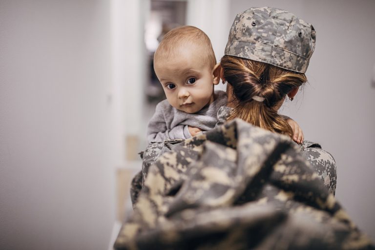 Woman soldier holding her baby son