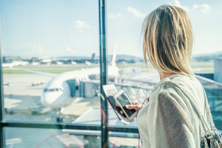 A woman in an airport looks out at the planes