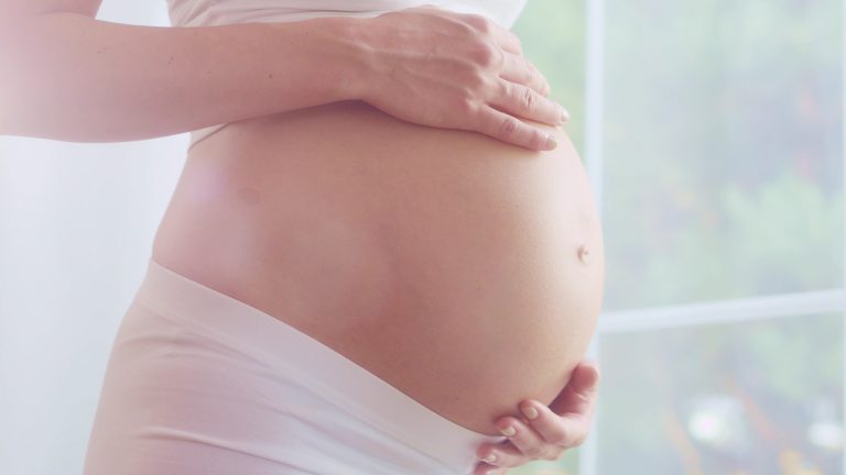 Close up on pregnant woman's belly.