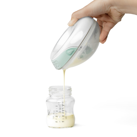 Milk being poured into a bottle from a Willow Go breast pump