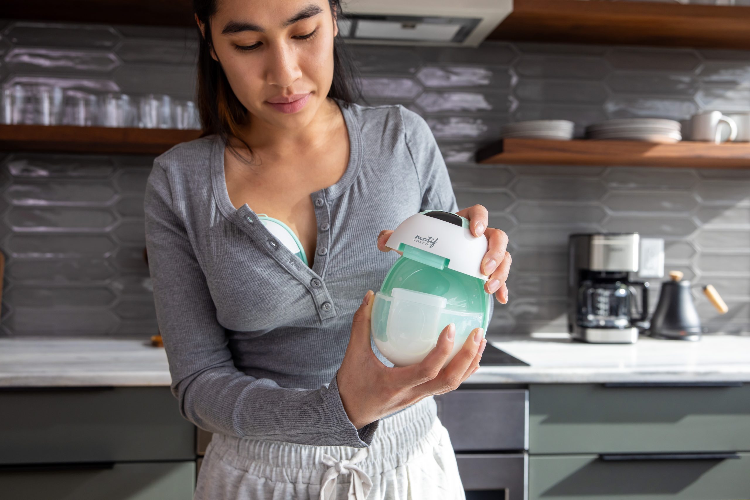 Motif Aura Glow Breast Pump An Image showing the Motif Aura Glow being opened up by a mom
