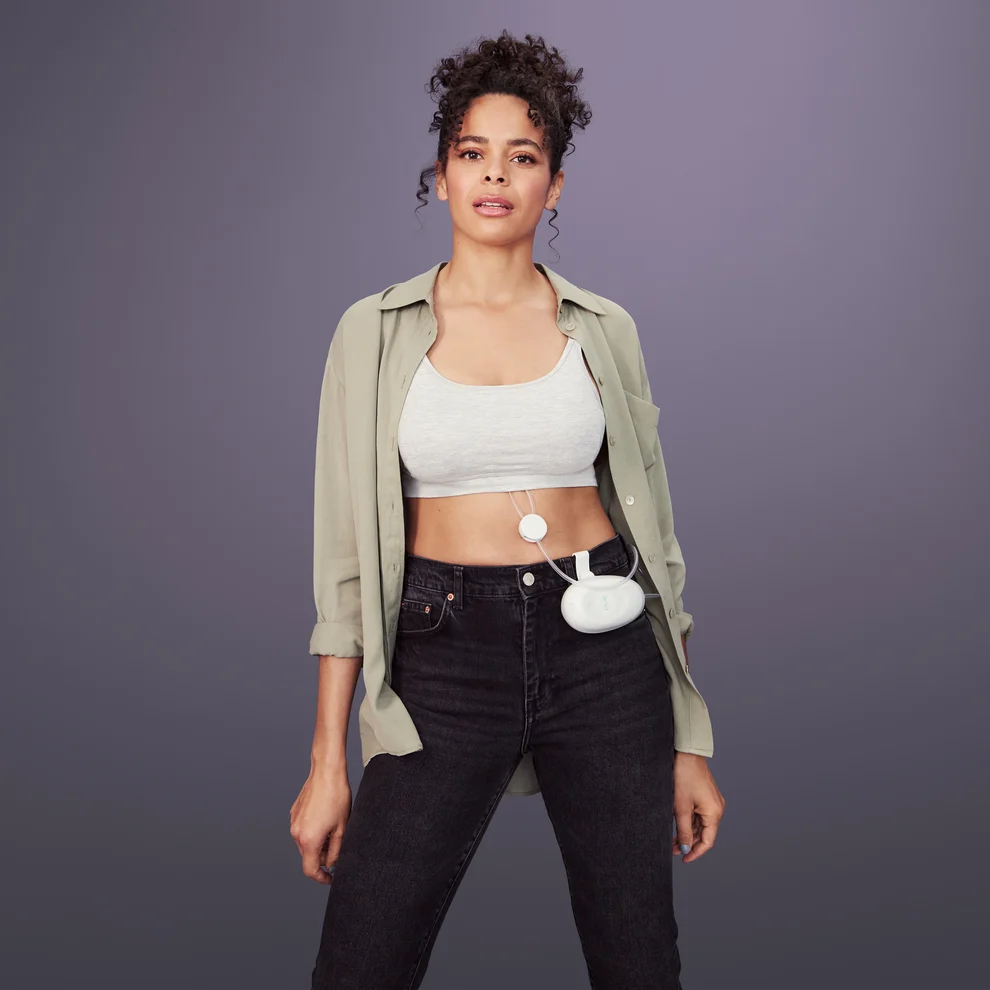 A woman uses an Elvie Stride breast pump under her clothing