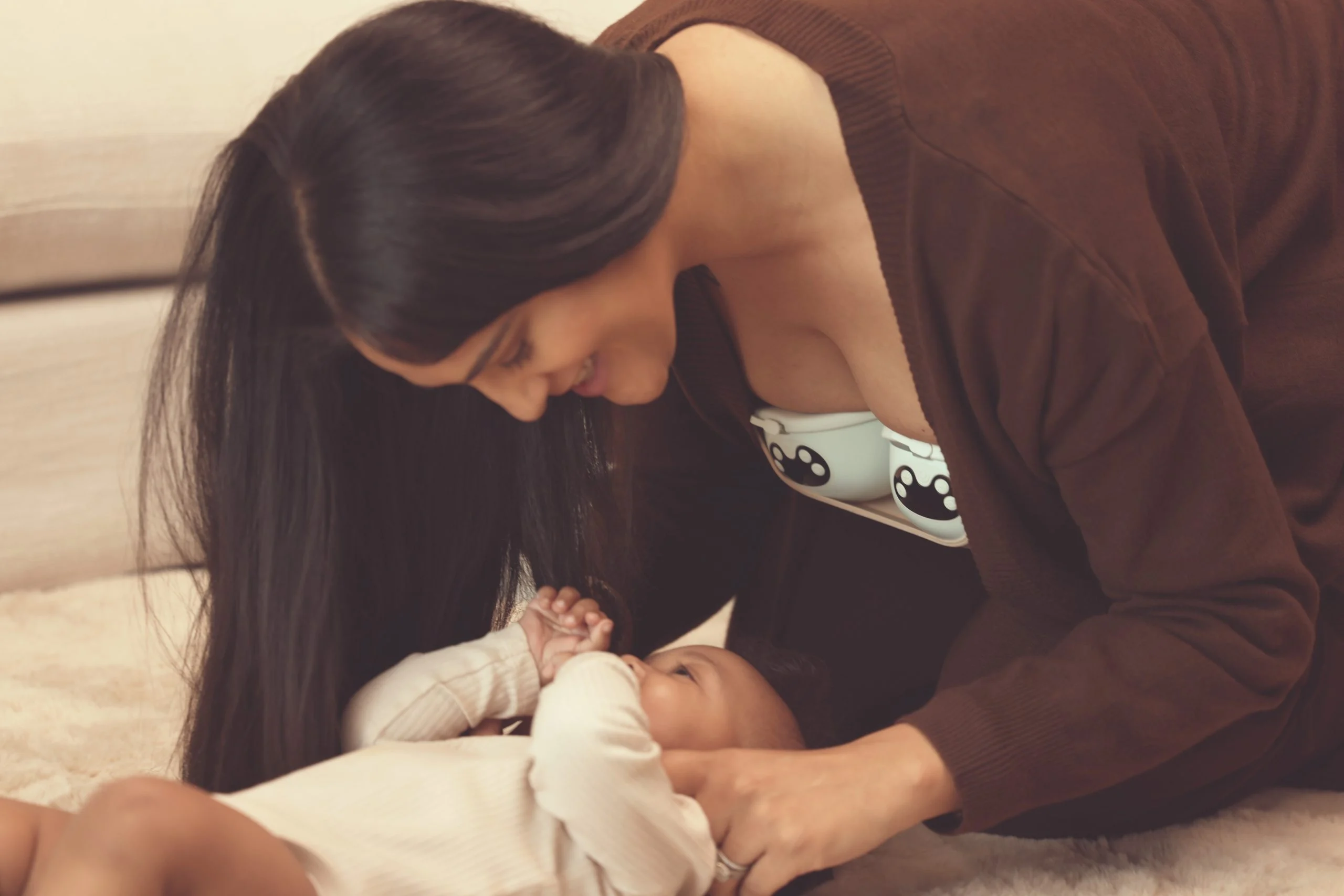 Mother bonding with newborn while wearing the Zomee Mother’s Nature W1 warming wearable breast pump for hands-free, comfortable pumping