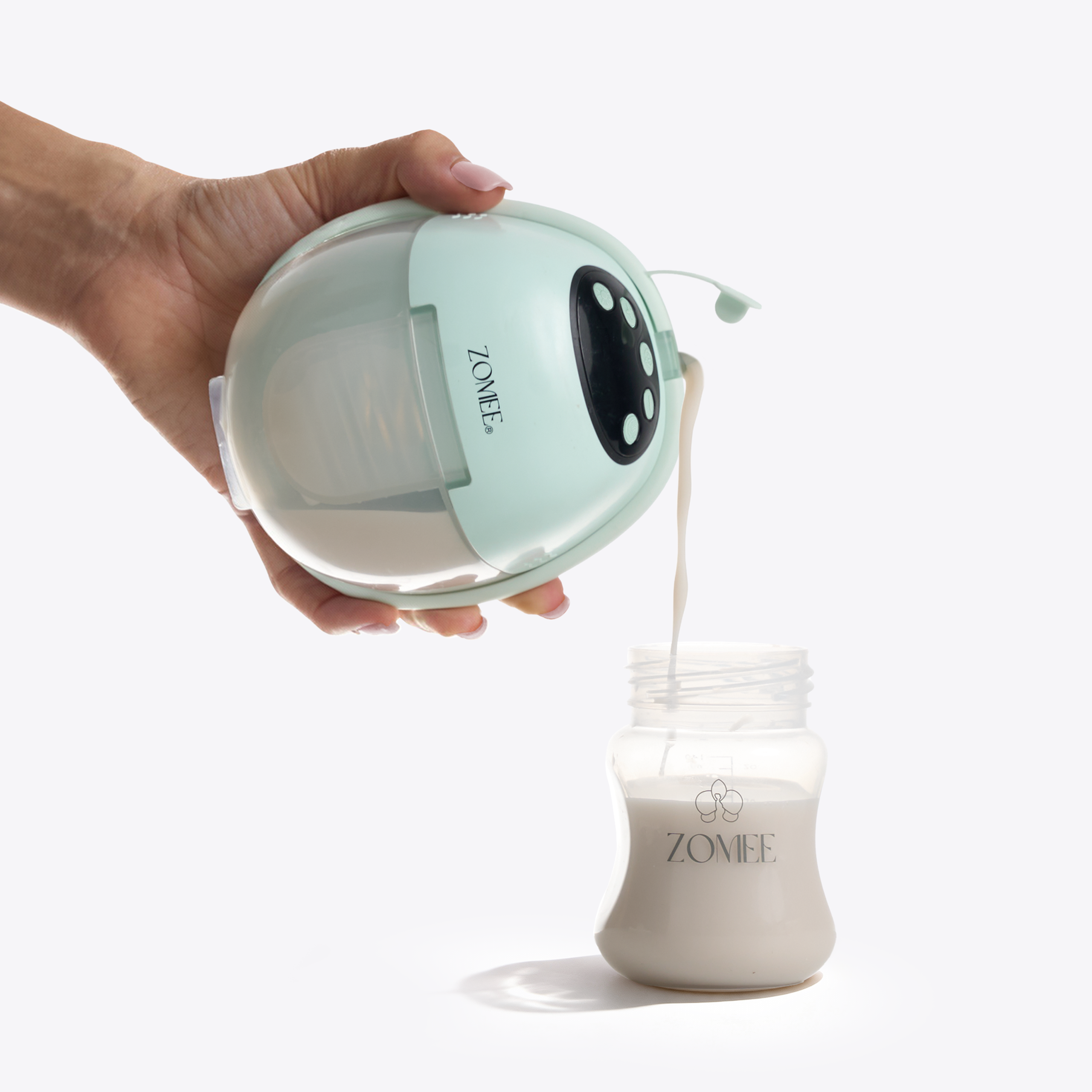Zomee Mother’s Nature W1 wearable breast pump pouring expressed breast milk into a storage bottle