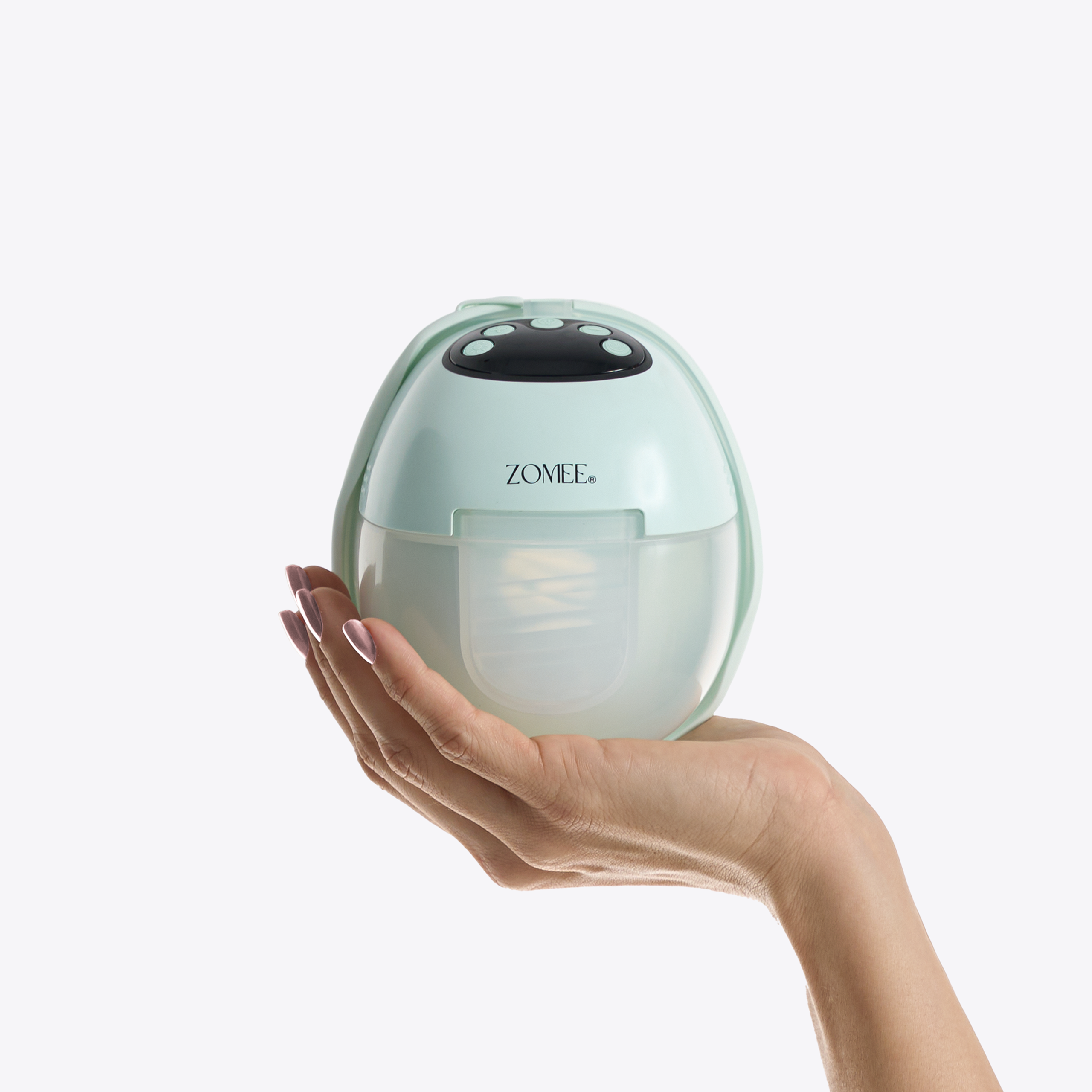 Hand holding the Zomee Mother’s Nature W1 wearable breast pump to show compact size and portability